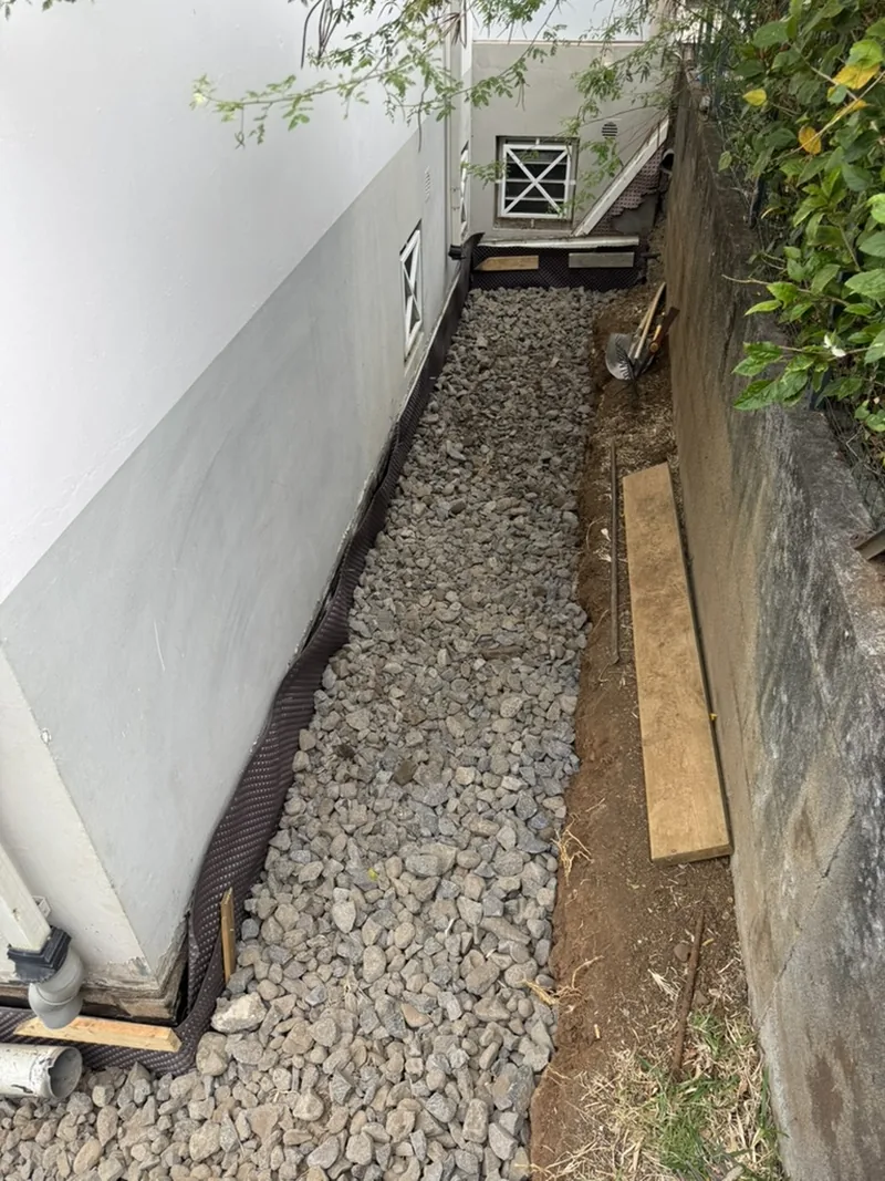 Drain et lit de galets posés le long du mur enterré